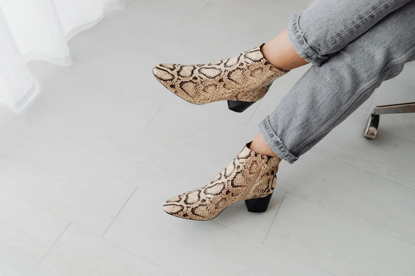 Kotníkové boty s hadím vzorem doplněné džínami
