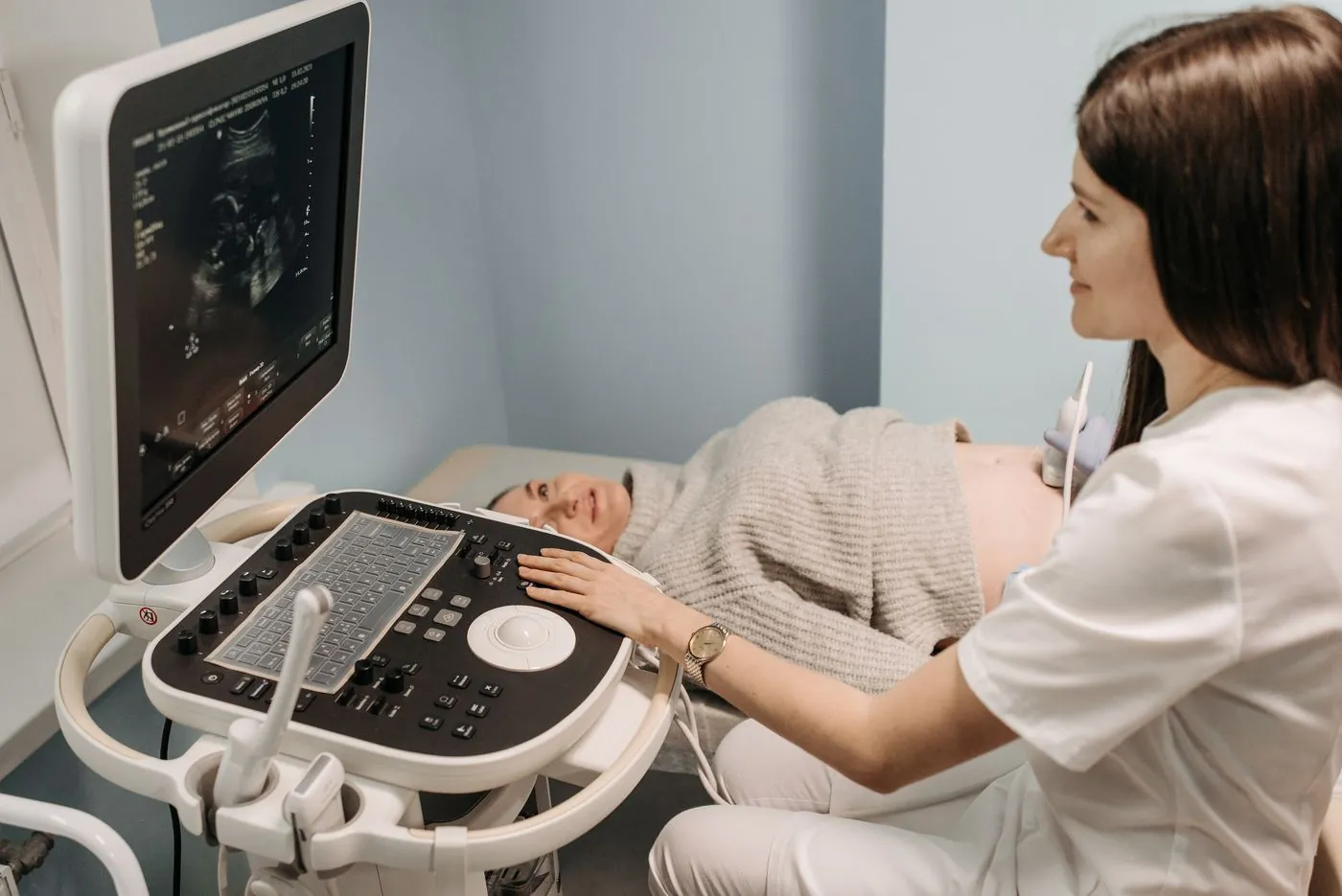 Lékařka provádí ultrazvukové vyšetření těhotné pacientce v ordinaci