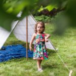 Distracted girl playing with string on homemade garden tent